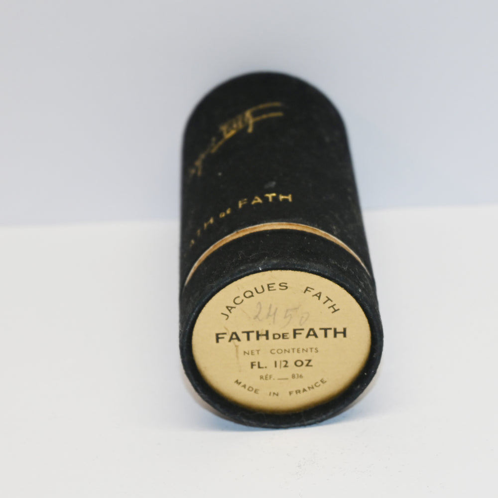 Vintage Fath perfume bottle with gold text on a white background